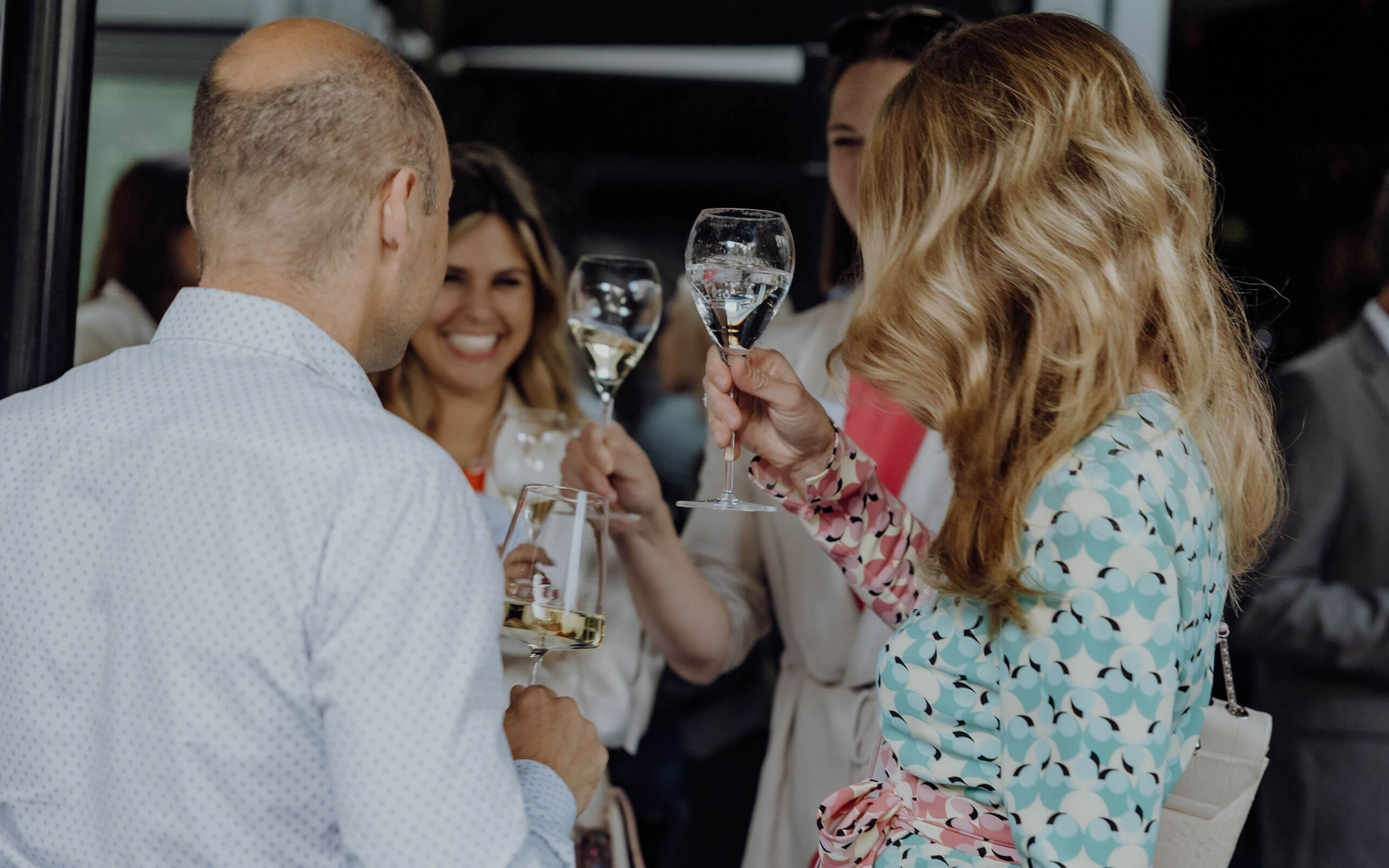 3 Frauen und 1 Mann die mit Champagner und Wein anstoßen im Roomers Berlin